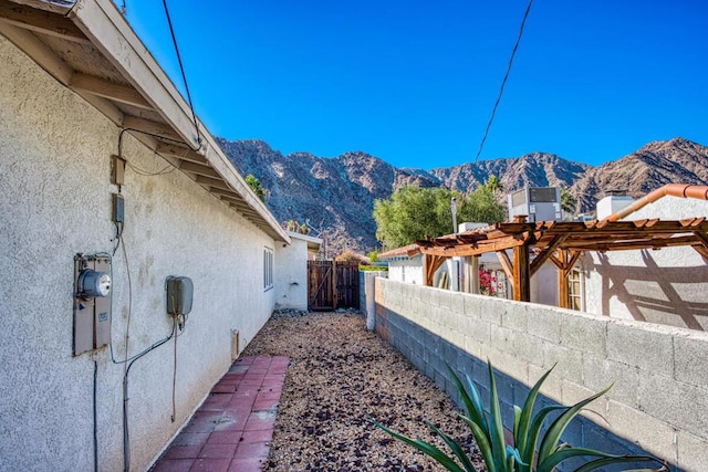 view of property exterior featuring a pergola and a mountain view