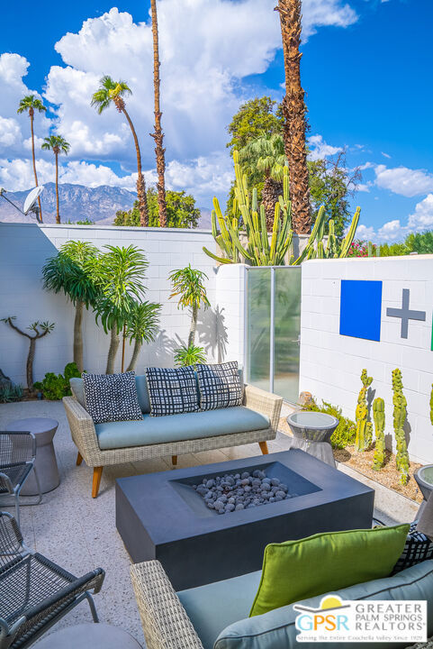 view of patio with a mountain view and an outdoor living space with a fire pit