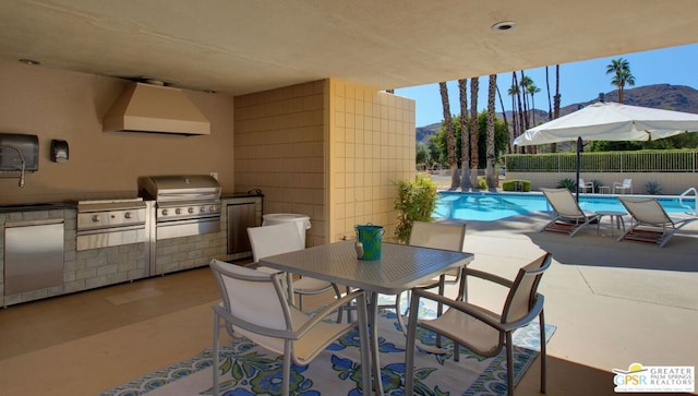 view of patio / terrace with a mountain view, grilling area, and a community pool