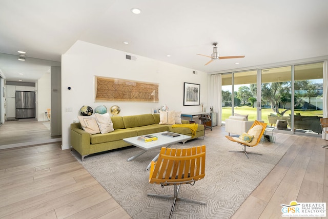 living room featuring light hardwood / wood-style flooring and ceiling fan