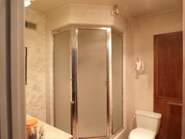 bathroom with walk in shower and toilet