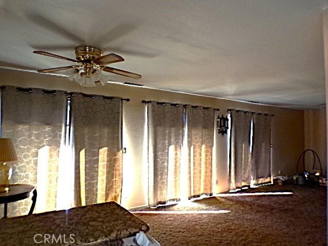 miscellaneous room with ceiling fan and carpet flooring