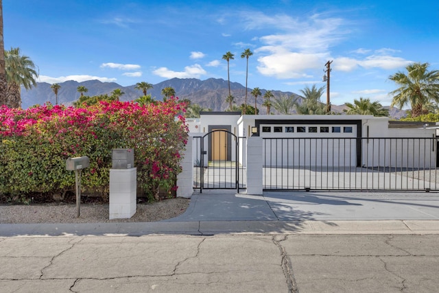 view of gate featuring a garage and a mountain view