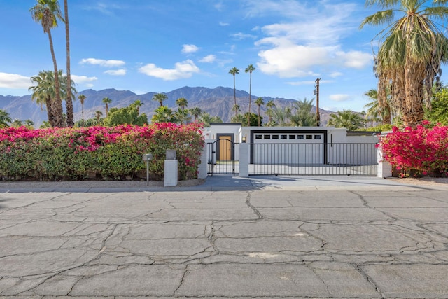 view of gate with a mountain view and a garage