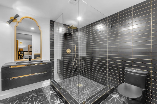 bathroom with vanity, a tile shower, and toilet