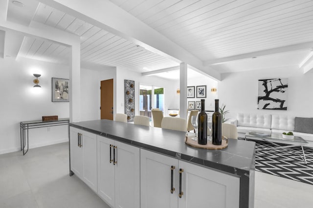 kitchen with white cabinetry and beam ceiling