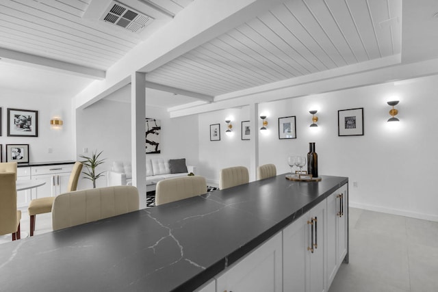 interior space with white cabinetry and beamed ceiling