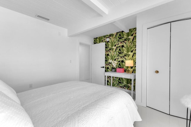 bedroom with beamed ceiling and a closet