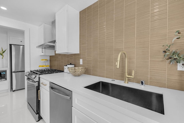 kitchen featuring sink, appliances with stainless steel finishes, tasteful backsplash, white cabinets, and wall chimney exhaust hood