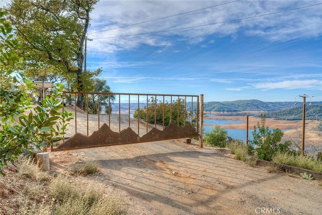 view of gate featuring a water and mountain view