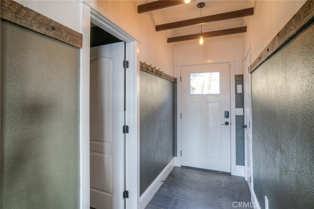 doorway featuring lofted ceiling with beams and dark tile patterned flooring