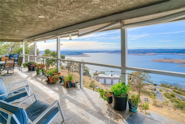 sunroom featuring a water view