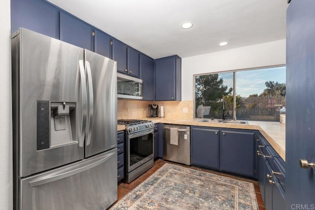 kitchen featuring backsplash, sink, blue cabinets, and stainless steel appliances