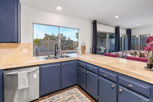 kitchen featuring stainless steel dishwasher, blue cabinets, and sink