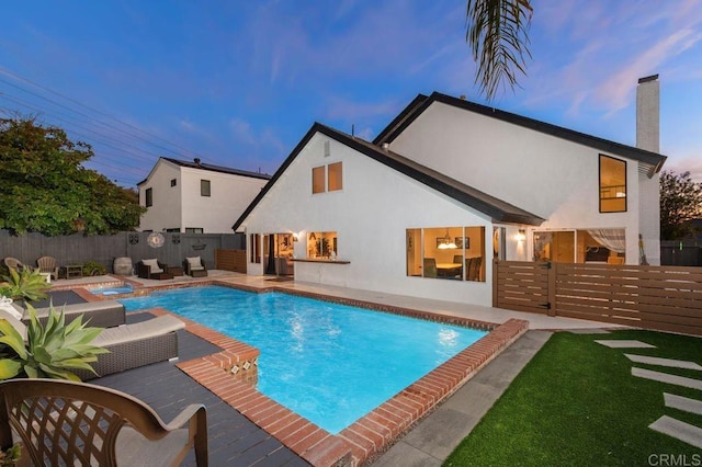 pool at dusk with a jacuzzi