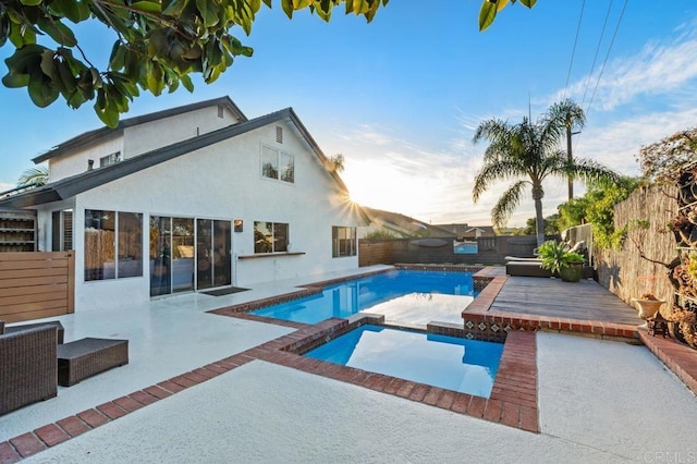 view of pool featuring a wooden deck, an in ground hot tub, and a patio area