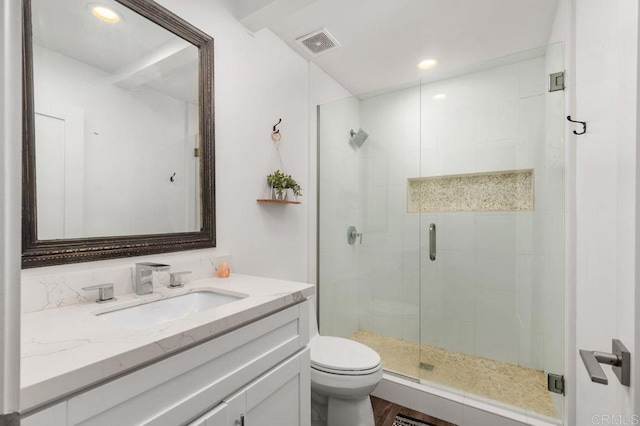 bathroom featuring hardwood / wood-style flooring, vanity, toilet, and a shower with door