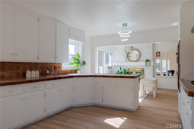 kitchen featuring light wood-type flooring, white cabinetry, and a wealth of natural light