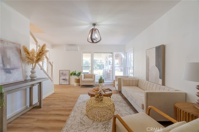 living room featuring an AC wall unit and light hardwood / wood-style floors