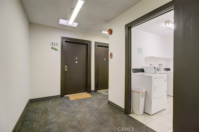 clothes washing area with light colored carpet, a textured ceiling, and independent washer and dryer