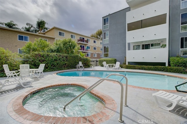 community pool featuring a patio and a hot tub