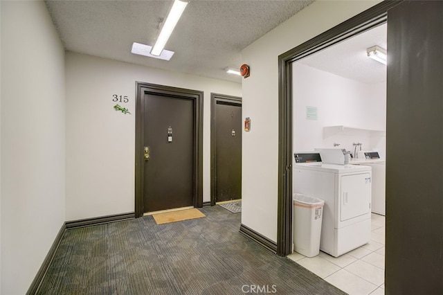 laundry room featuring washing machine and dryer, light carpet, and a textured ceiling