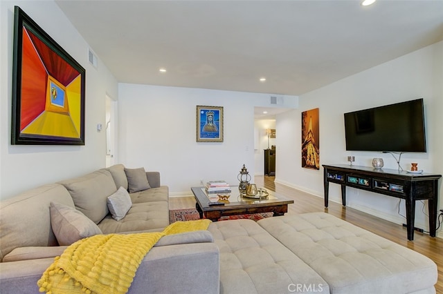 living area with recessed lighting, visible vents, baseboards, and wood finished floors