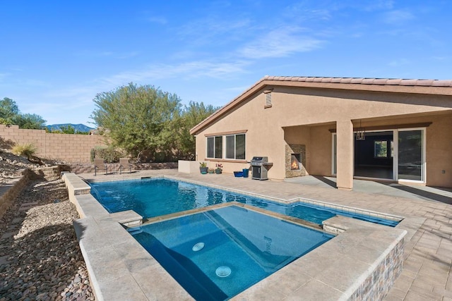 view of pool with an in ground hot tub, a patio, and area for grilling