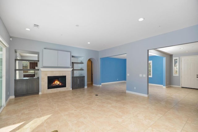 unfurnished living room with a wealth of natural light and a fireplace