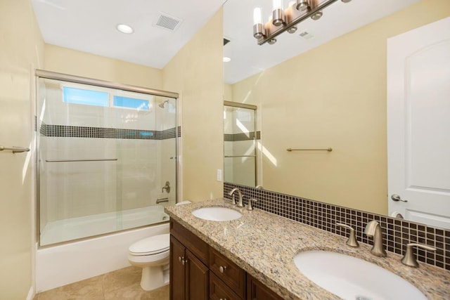 full bathroom featuring vanity, backsplash, tile patterned flooring, toilet, and enclosed tub / shower combo