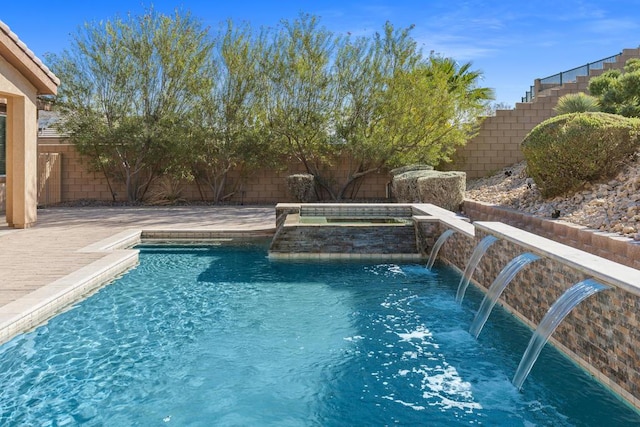 view of swimming pool featuring a patio area, an in ground hot tub, and pool water feature