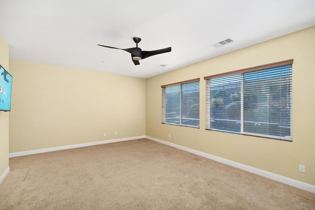 carpeted spare room with ceiling fan