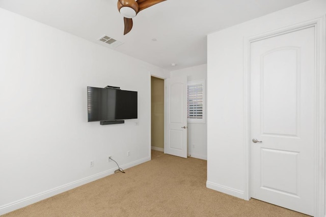 unfurnished bedroom featuring ceiling fan and light carpet