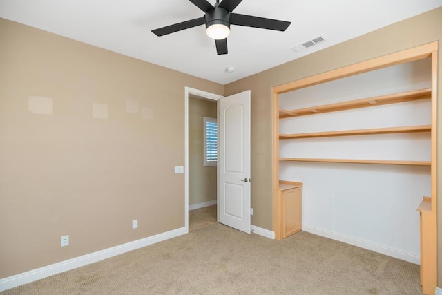 unfurnished bedroom with light carpet, a closet, and ceiling fan