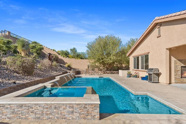 view of pool with area for grilling, pool water feature, and an in ground hot tub