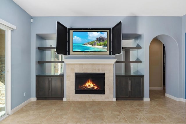 unfurnished living room featuring a tile fireplace and plenty of natural light