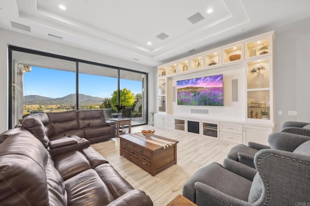 home theater featuring light hardwood / wood-style floors and a raised ceiling