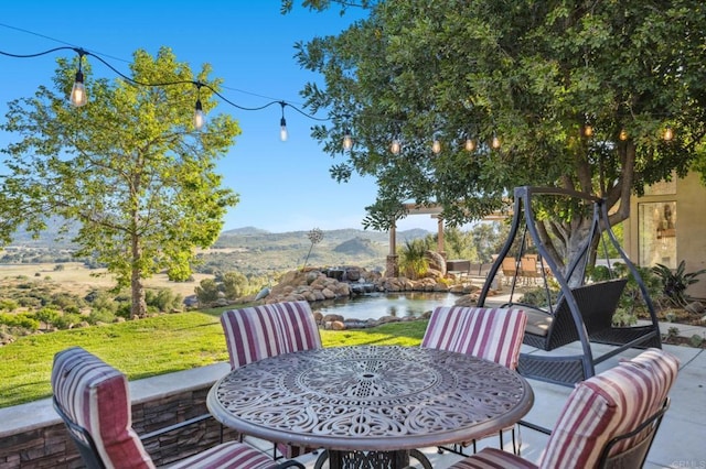 view of patio / terrace with a water and mountain view