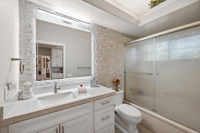 full bathroom featuring shower / bath combination with glass door, vanity, and toilet