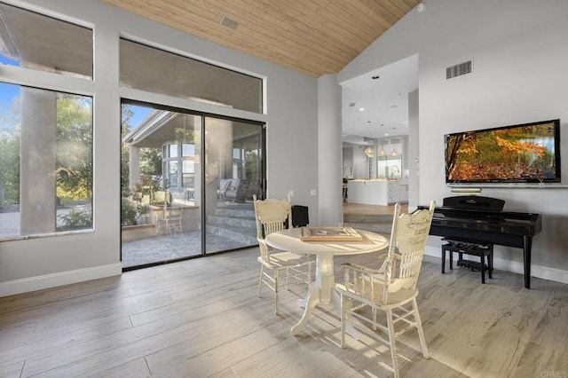 dining space with wood ceiling, lofted ceiling, and light hardwood / wood-style floors