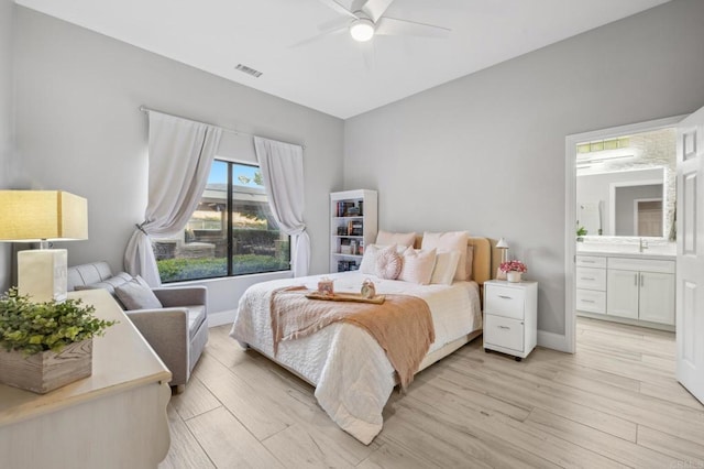 bedroom featuring ceiling fan, light hardwood / wood-style floors, sink, and connected bathroom