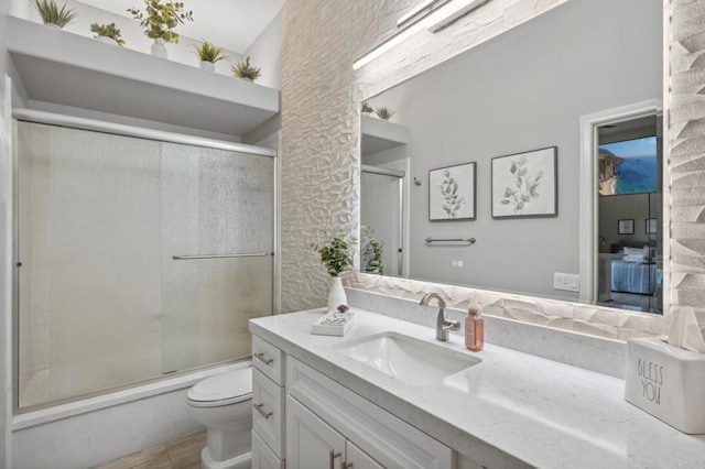 full bathroom with vanity, toilet, and bath / shower combo with glass door