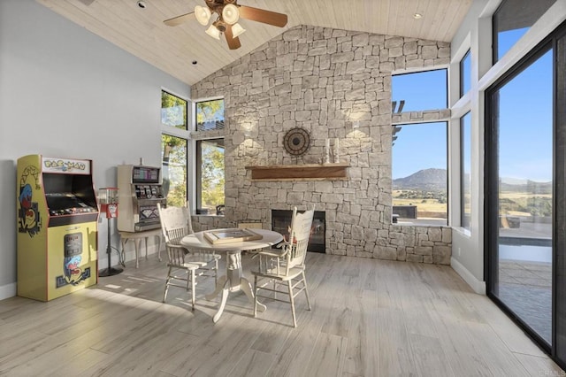 dining area featuring ceiling fan, light hardwood / wood-style flooring, high vaulted ceiling, a mountain view, and wood ceiling