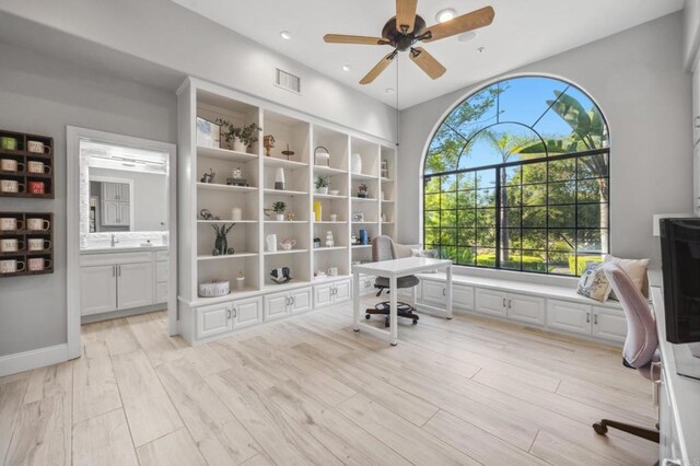 office featuring light wood-type flooring, ceiling fan, and sink