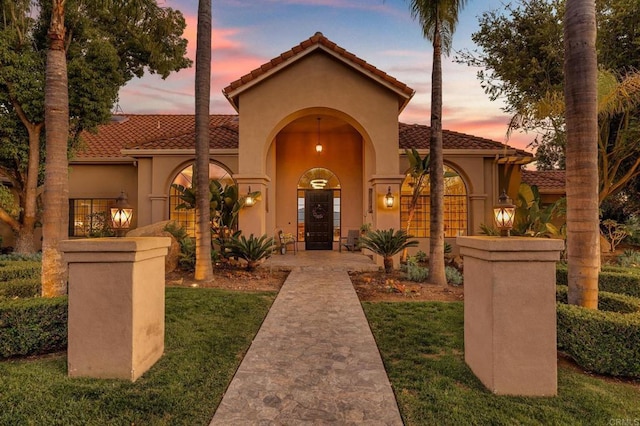 mediterranean / spanish-style home with stucco siding and a tiled roof