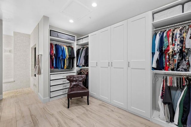 spacious closet with attic access and light wood-style floors