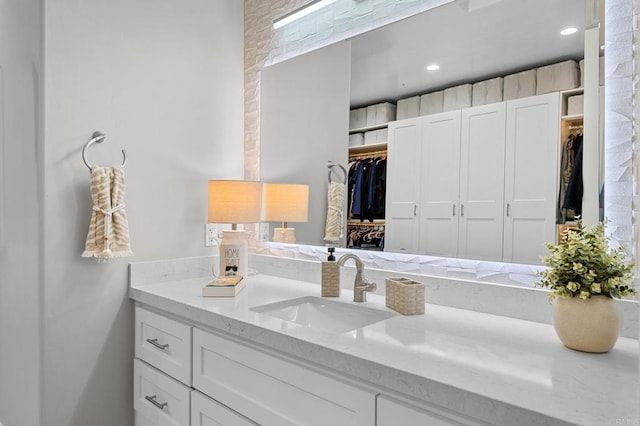 bathroom with vanity and a walk in closet