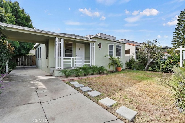 view of front of property with a front lawn, a carport, and a porch