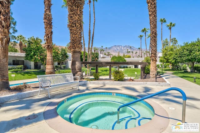 view of pool with a mountain view, a community hot tub, and a pergola