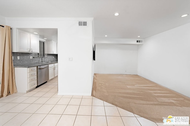 kitchen featuring white cabinets, dishwasher, light tile patterned floors, and tasteful backsplash